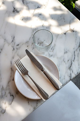 Luxury table setting on marble table with side plate and dappled shadow light