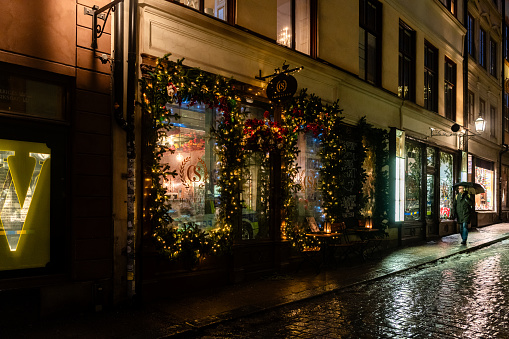 A man walking past the Christmas decorated exterior of the historic Cafe Schweizer established in 1920 in Gamla Stan, Stockholm