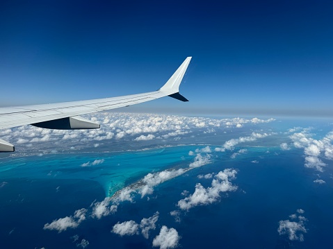 View of airplane wing above Isla Mujeres and the Mexican coastline while landing in Cancun, Quintana Roo, Mexico
