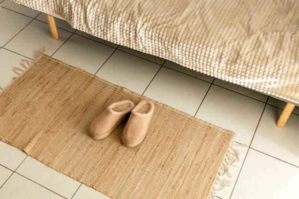 istock Uggs slippers on the rug by the bed. 2091641050