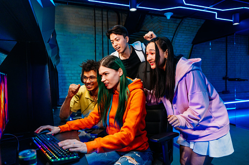 Multiethnic group of young friends playing videogames - Team of professional esport gamers playing in competitive video games on a cyber Games Tournament