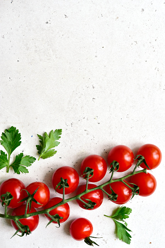 Fresh ripe tomatoes on a white slate, stone or concrete background. Top view with copy space.