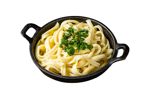 German Spaetzle egg Noodles with Butter and Parsley in a skillet.  Isolated on white background. Top view