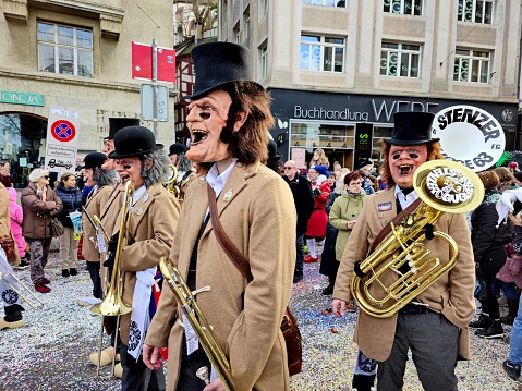The Carnival of Basel (Basler Fasnacht) is the biggest carnival in Switzerland and takes place every year between February and March in Basel. The image shows seveal Participants of the carnival parade with musical instruments.