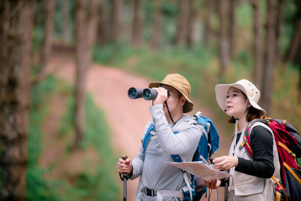 istock Attractive young couple hiking in the forest using binoculars. 2091713468