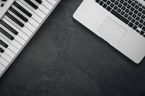 istock Music keys and laptop on a textured black background, flat lay, copy space. 2091733700