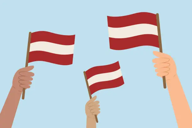 Vector illustration of Diverse hands holding flags of Latvia. Vector illustration of Latvian flags in flat style.