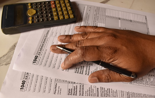 A closeup picture of a 1040 forms on a table with a black pen on it. US tax form.