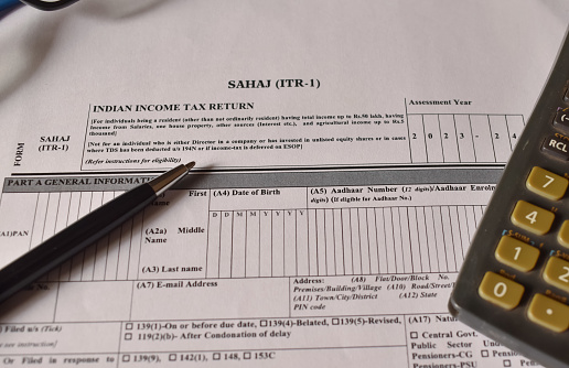 A closeup picture of ITR 1 forms on a table with a black pen on it. Indian tax form.