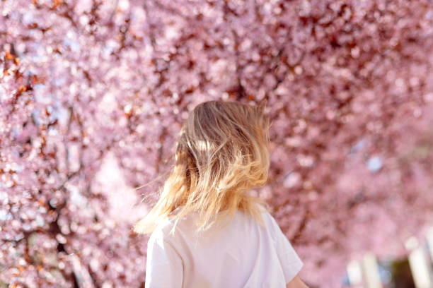 istock Smiling girl looking to a blooming tree 2091778924