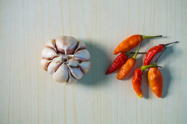 Chili peppers and garlic on a wooden background