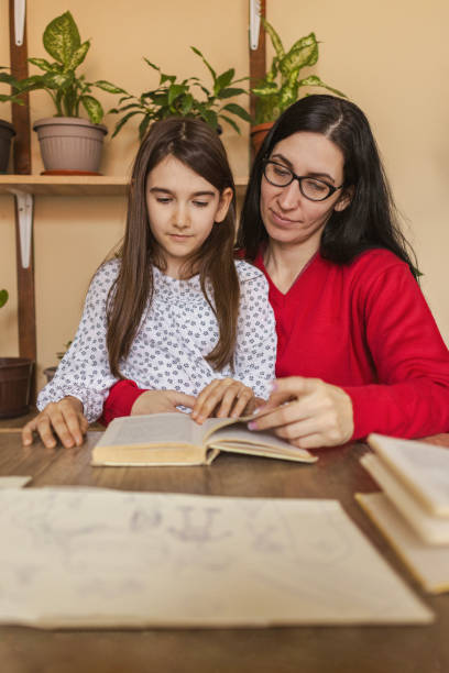 istock Happy child joining her mommy in reading books 2091834043
