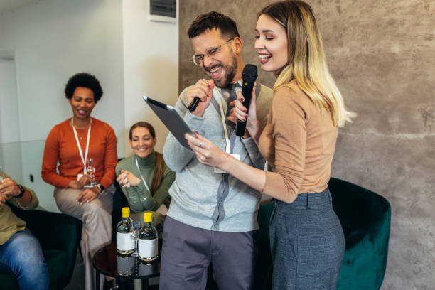 istock Business people making team training exercise during team building seminar singing karaoke and drinking. 2091854278