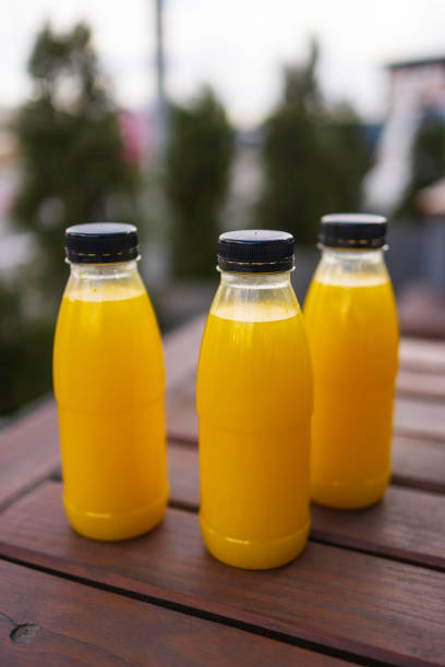 plastic bottles with orange juice on the wooden table