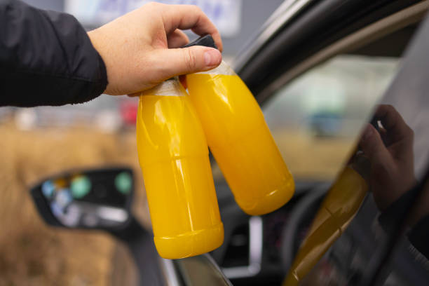 plastic bottle with fresh orange juice in a passenger car