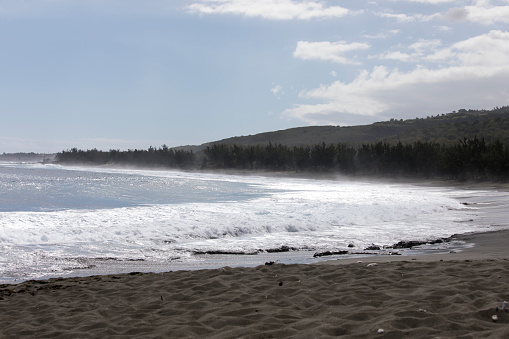 A photo of beach with black sand in La Reunion