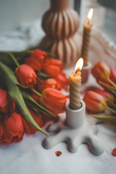 istock Candle and bouquet of red tulips, spring aesthetics 2091893486