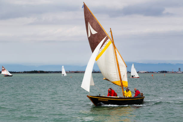 regata di venezia, tradycyjne weneckie regaty to najbardziej oczekiwane zawody sportowe w wenecji. zbliżenie na żaglówkę z żaglem i jej załogę lub załogę wioślarską - regatta sports race sailing nautical vessel zdjęcia i obrazy z banku zdjęć