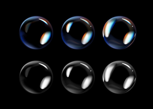 Glossy soap bubbles on black background. Transparent soap bubbles with reflection.