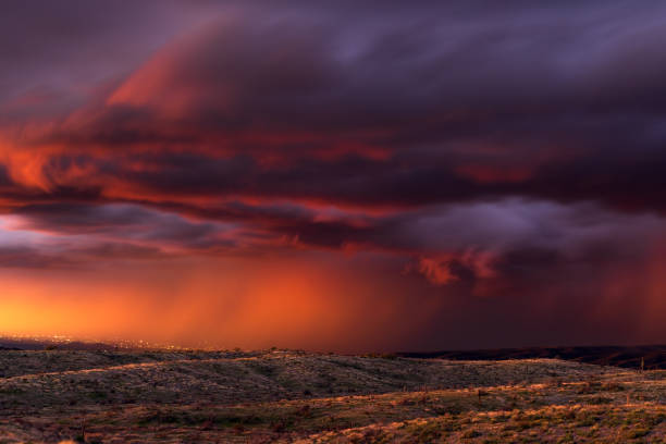 Stormy sunset sky with dramatic clouds and rain falling in the Arizona desert.