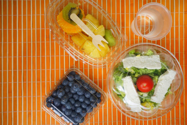 Directly above view of fresh healthy food in plastic boxes on a garden table.