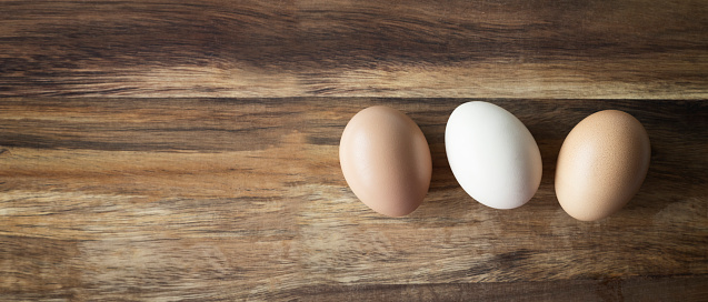 Hen eggs on wooden empty space background package design. Organic eggs concept.