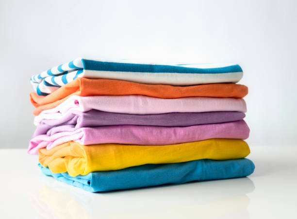 istock Stack of cotton colorful clothes on white table closeup. Clothing pile, folded apparel. 2092101649