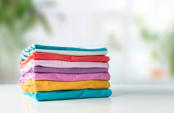 istock Stack of cotton colorful clothes on white table empty copy space.Clothing pile, folded apparel. 2092101652