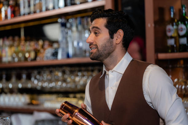 istock Man bartender is making a drink and dancing at bar. Dance party with group people dancing . Women and men have fun and drinking martini cocktail in night club. 2092111413