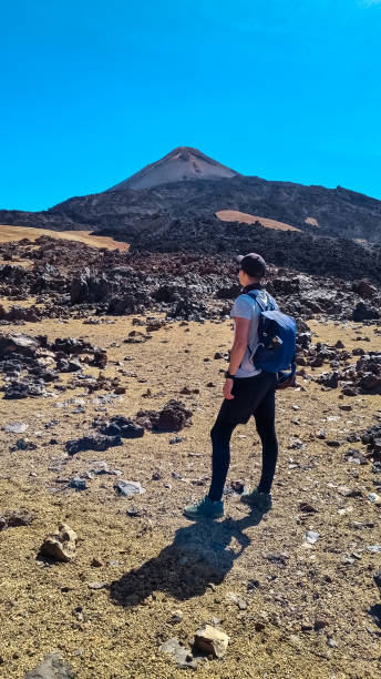 istock Teide - Man with backpack on volcanic desert terrain hiking trail leading to summit volcano Pico del Teide, Tenerife, Spain. 2092131933