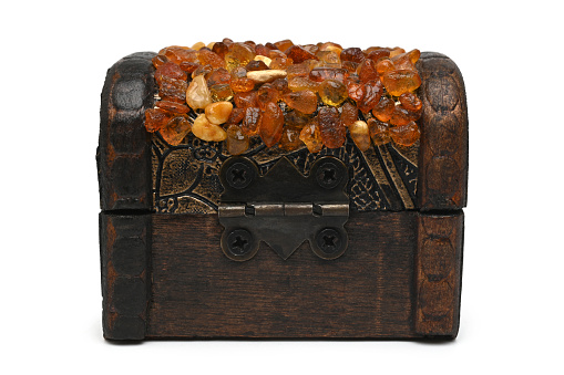Old wooden casket inlaid amber on white background