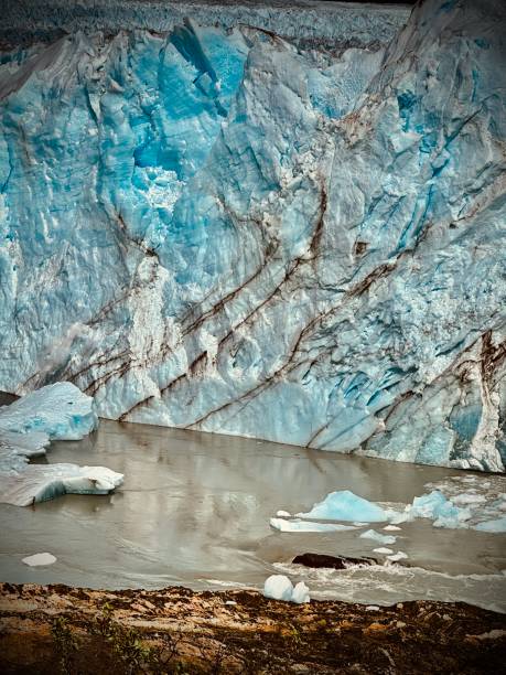 de color gris oscuro son las grietas dentro de la pila de hielo azul que es el término del glaciar perito moreno sobre las aguas del lago argentina - patagonia ice shelf vertical argentina fotografías e imágenes de stock