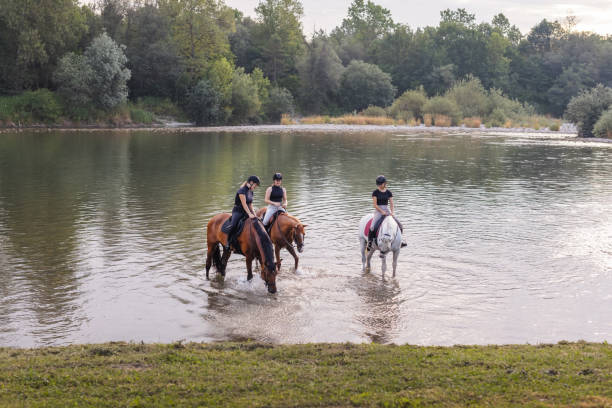 istock Three women enjoying equestrian leisure and river, sitting on horses 2092170569