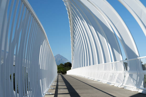 New Plymouth. New Zealand - March 1 2024; Cyclist crossing white steel Te Rewa Rewa Bridge landmark on Coastal Walkway in New Plymouth Taranaki.