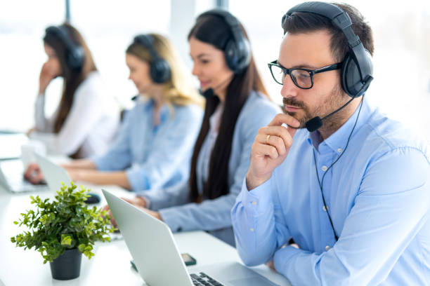 istock Serious call center agent in headset with microphone consulting and listening to client during phone call at call center 2092188426