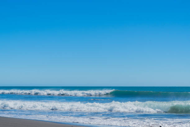 Glistening water and breaking waves at Oakura Beach on North Island west coast, Taranaki New Zealand.