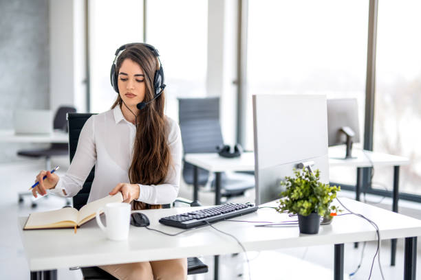 istock Beautiful brunette young woman willing to take notes in her notebook while working on computer in office. 2092205105