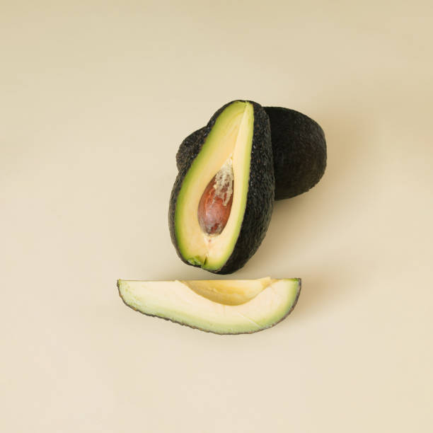 istock Avocado with copy space on beige background. Sliced fresh ingredient 2092223833