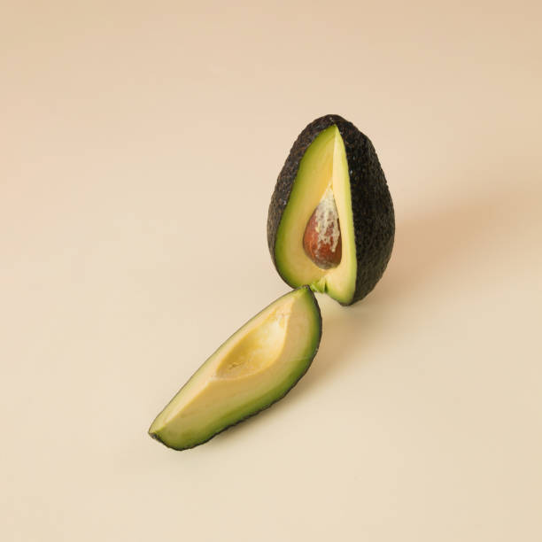 istock Avocado with copy space on beige background. Sliced fresh ingredient 2092223834