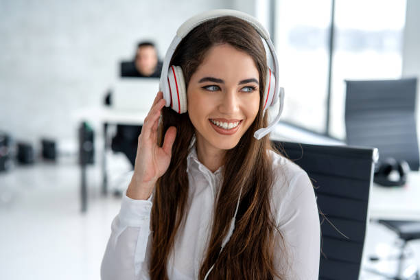 istock Smiling customer support agent in headset listening and talking to client while having online chat at call center. 2092244991