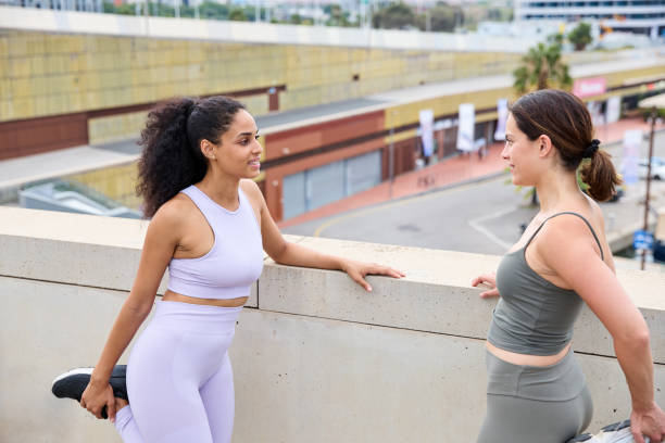 istock Two sports friends doing a leg stretching exercise while exercising outdoors on a sunny day 2092248057