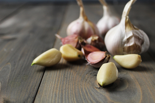 Peeled garlic cloves on gray background close-up. Spicy ingredients in cooking. Garlic as a condiment.