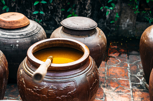 A close-up view of traditional Vietnamese fermentation jars with bubbling liquid, showcasing cultural food preservation techniques in Hanoi.