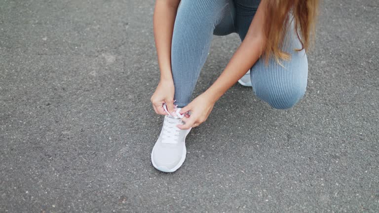 Unrecognisable sportswoman tying the laces of her running shoes.