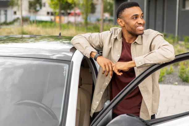 istock African american man getting into a white car, opened the car door 2092297585