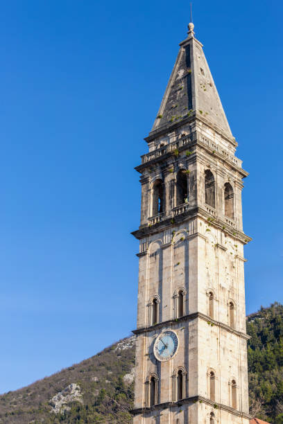 istock Bell tower in Perast, Montenegro with a clock face, stands out against the blue sky, overlooking Kotor Bay. Vertical shot, copy space 2092299613