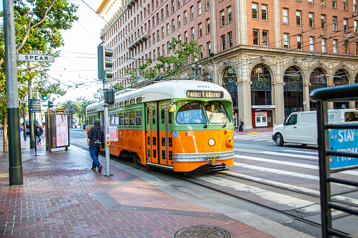 San Francisco, USA - May 20, 2022:  orange vintage bus operates from Fisherman's wharf to market street downtown San Francisco. Tourists enjoy traveling with this electric vintage bus.