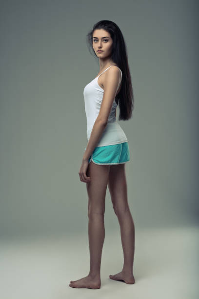 Poised and grounded, a slender woman stands reflecting a blend of grace and determination