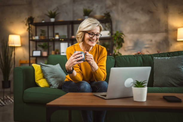 istock Mature blonde caucasian woman use laptop computer at home for work 2092327917