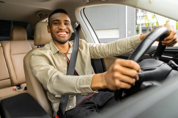 istock African American driver with hands on steering wheel looking at camera 2092328423